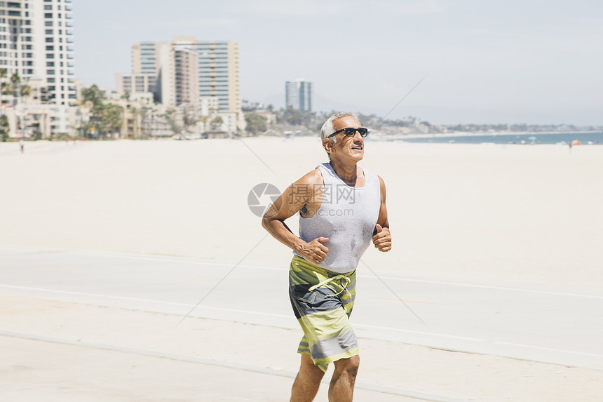 年长男子在美国加利福尼亚州长滩海上奔跑图片