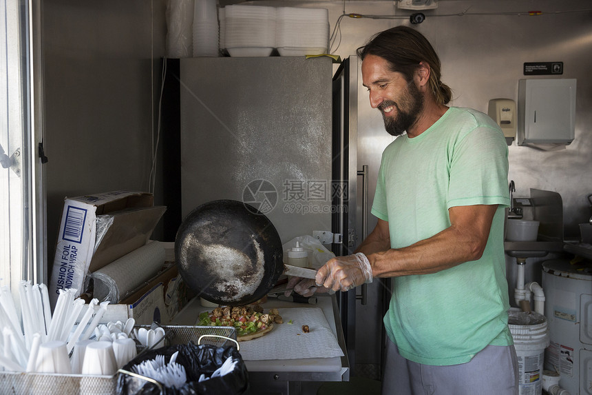 便利餐车上做饭的男性图片