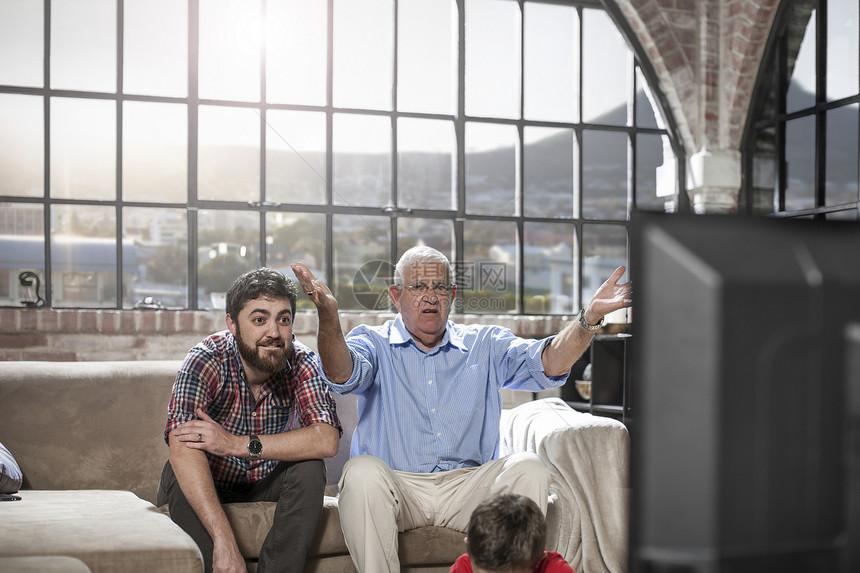 父亲和儿子在家看电视图片