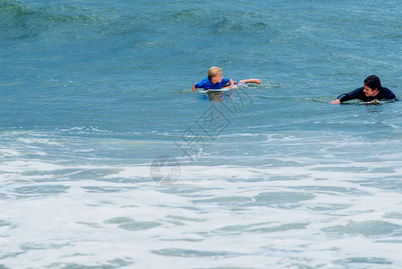 海中冲浪的男孩父子在海中背景