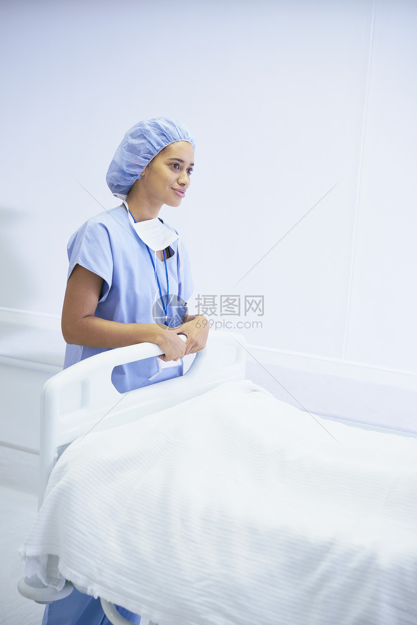 女护士在医院床位旁站立图片