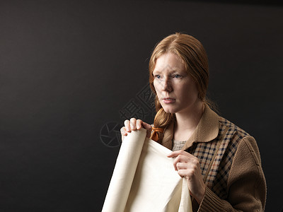 年轻女设计师拿着织物沉思图片