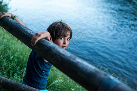 男孩在河边仰望镜头图片