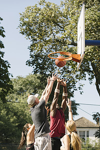 男女篮球运动员向篮筐投球背景图片