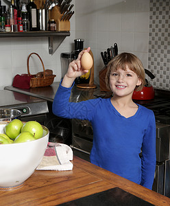坐在厨房里拿着鸡蛋的年轻女孩肖像高清图片