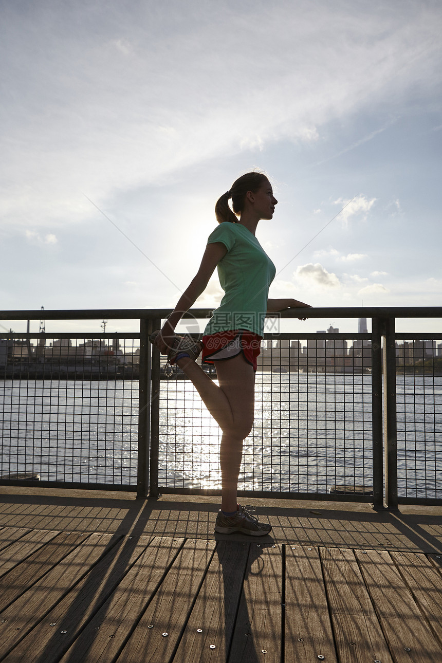 美国纽约曼哈顿码头妇女伸展腿的侧面视图图片