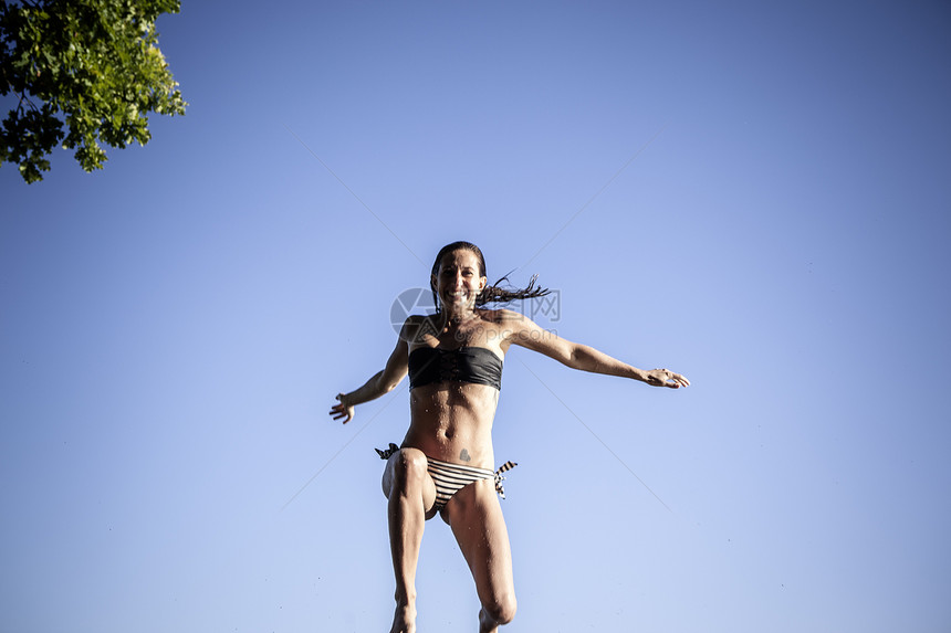 妇女穿着比基尼在空中跳跃图片