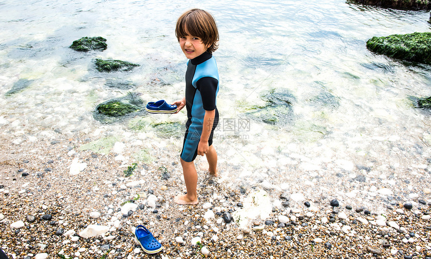男孩赤脚走在海滩上图片