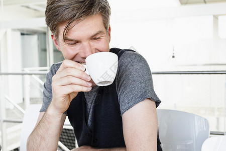 男人拿着茶杯微笑图片