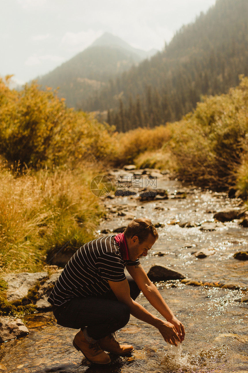 蹲在溪边吸收的男人图片