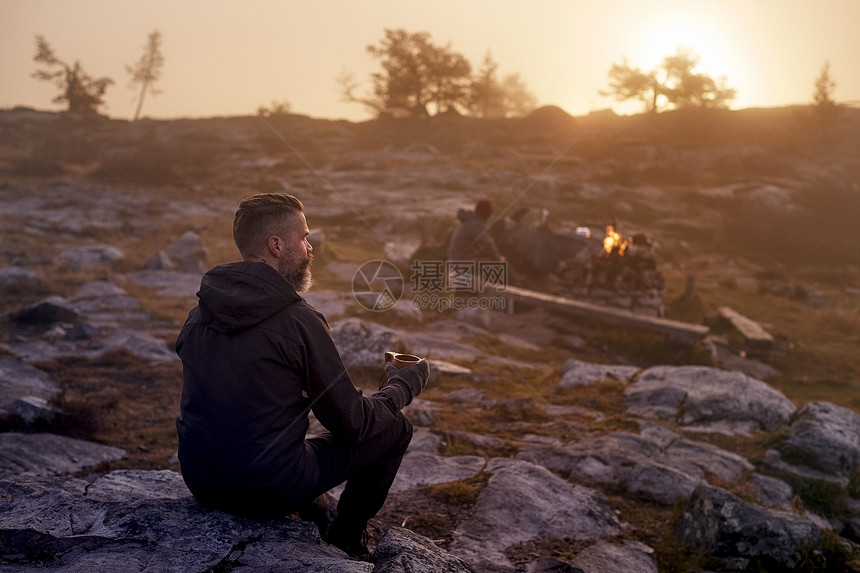 芬兰拉普兰萨基通图里一位徒步旅行者在岩石场上喝咖啡放松图片