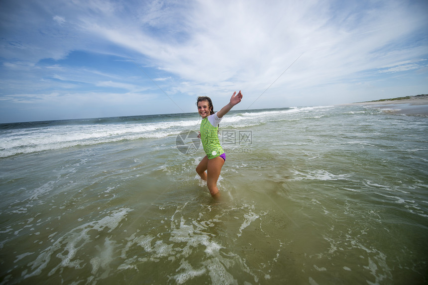 女孩在海浪中行走图片