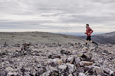 岩石悬崖顶上的男子正在跑步图片