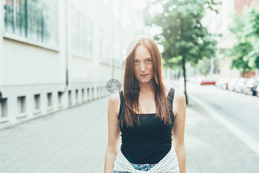 站在街上长着红发的年轻女人肖像图片