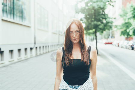 站在街上长着红发的年轻女人肖像图片
