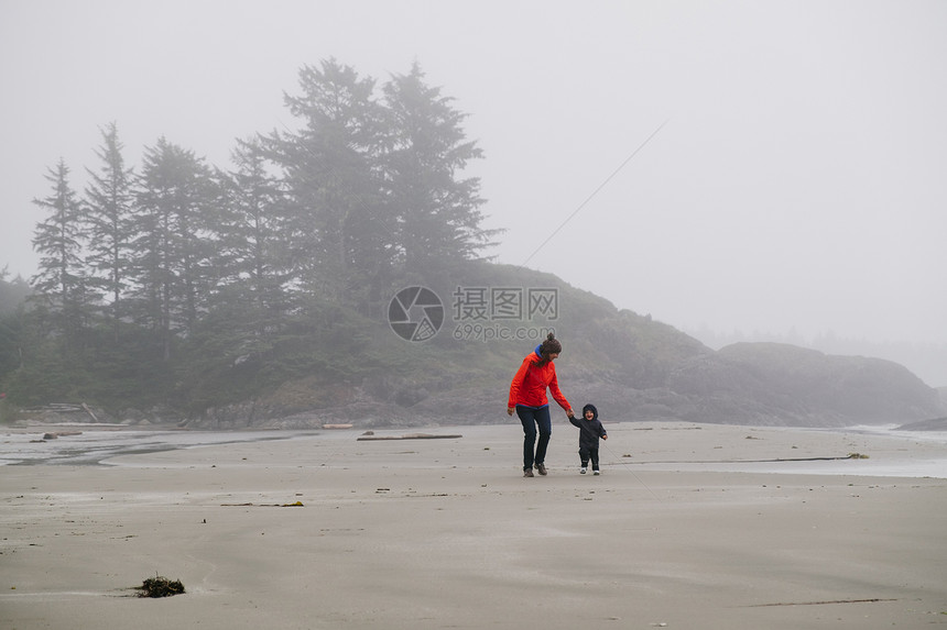母亲和儿子在加拿大不列颠哥伦比亚省温华岛长海滩上散步图片