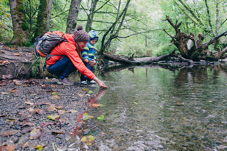 加拿大不列颠哥伦比亚省温华母亲和儿子在森林中探索溪流图片