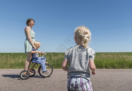 农村地区骑三轮车的母亲和儿童图片