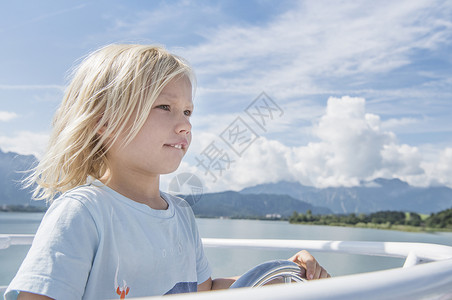 德国巴伐利亚富森男孩驾驶船向前看图片