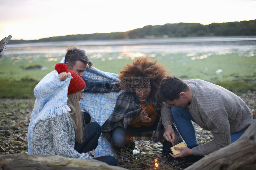 青年朋友在海滩上点燃营火图片