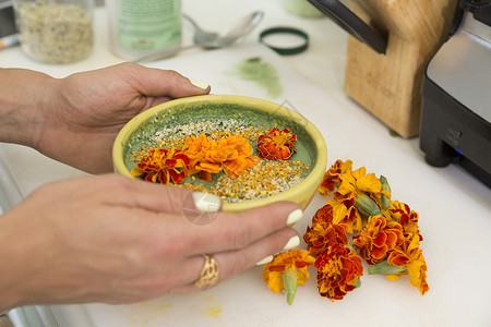 女人手拿着一碗装饰着鲜花的食物的截图图片