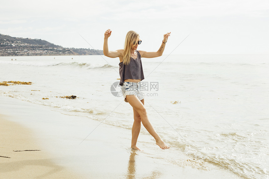 妇女在海岸沿的滩上划船图片