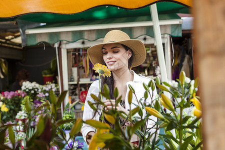 克罗地亚达尔马提斯普利特达尔马提亚市场摊位上鲜花闻的年轻女游客图片