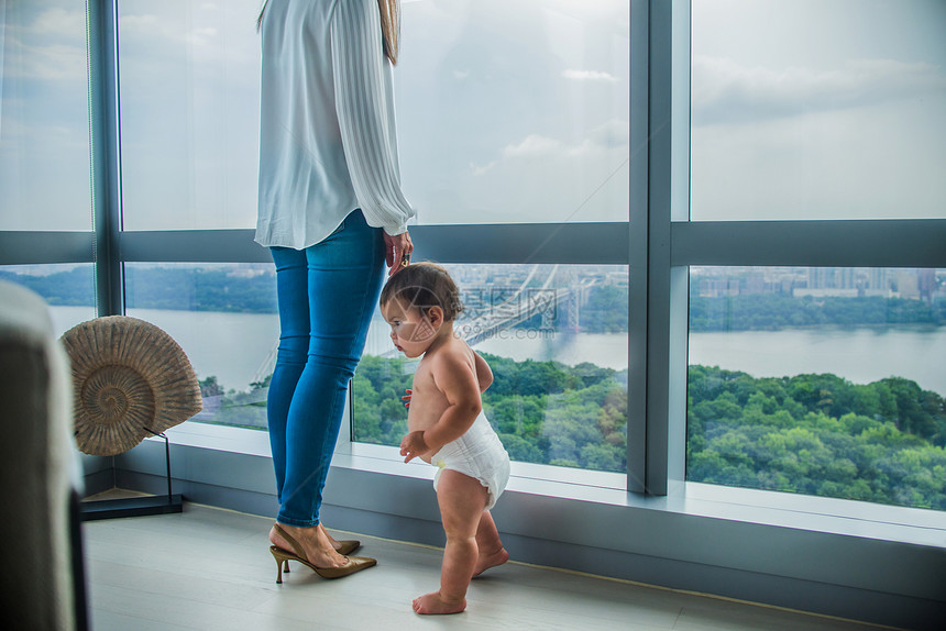 母亲和儿子在窗户上俯视的海湾图片