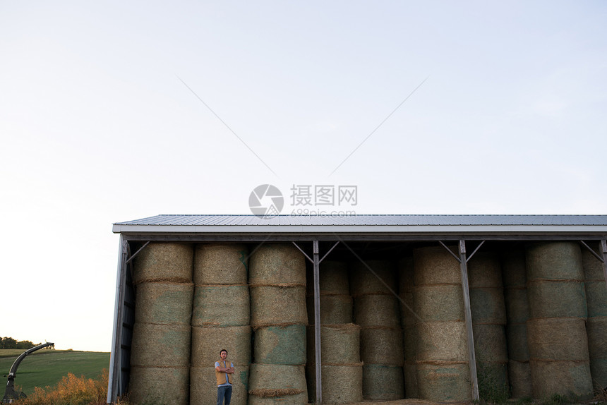农民站在干草棚前图片