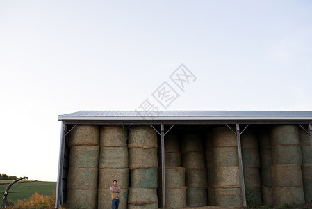 农民站在干草棚前图片