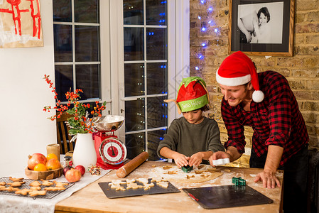 男人和儿子在厨房做圣诞饼干图片