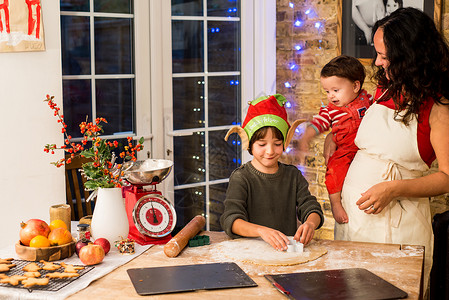 油酥面团在厨房母亲和儿子一起准备圣诞饼干背景