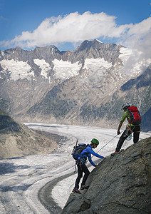 阿莱奇冰川在瑞士瓦利斯州冰川上爬山脊的一对夫妇背景