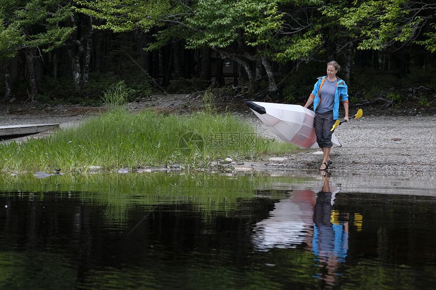加拿大新斯科舍湖水边拿皮划艇的运动员图片