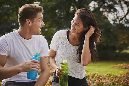 男人和女人在公园中锻炼喝水时聊天图片
