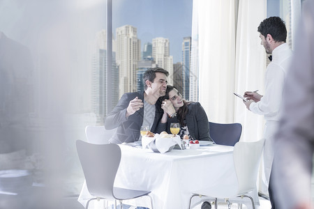 浪漫的年轻夫妇在旅馆餐厅点餐图片