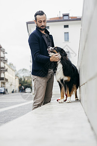 男性在街上遛狗图片