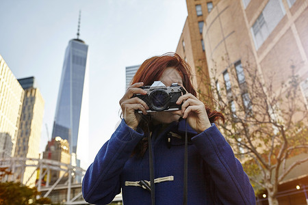 在美国纽约曼哈顿世界贸易中心门前拍摄照片的年轻女游客图片
