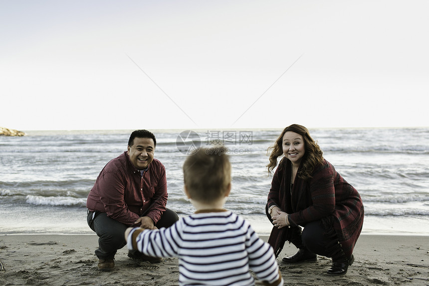一家三口在海滩上玩耍图片
