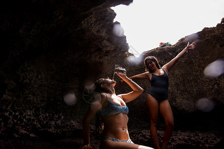 穿着泳衣在岩洞中喝酒的两名女性图片