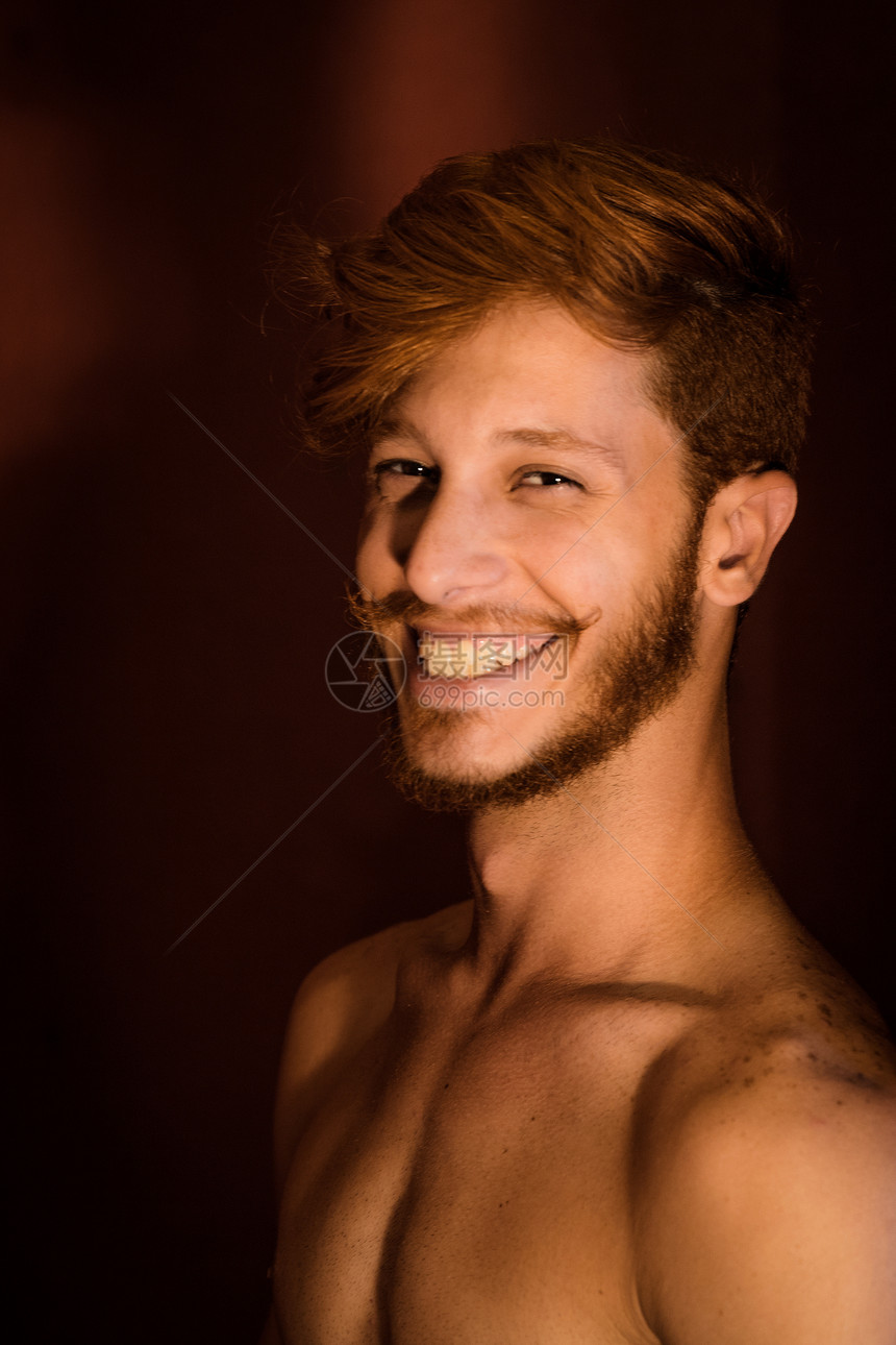 红色头发微笑的年轻男子肖像图片