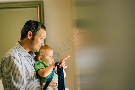 真人小孩父亲抱着小儿子望窗外背景