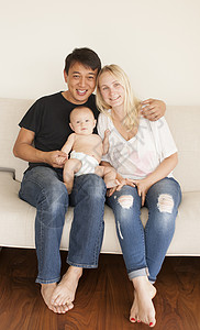 父母坐在沙发上与婴儿合照图片