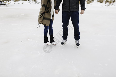 在冰冻湖上滑冰的情侣特写图片