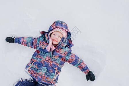 女孩开心的躺在雪中高清图片