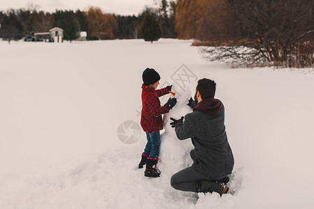 父亲和女儿做雪人背景图片