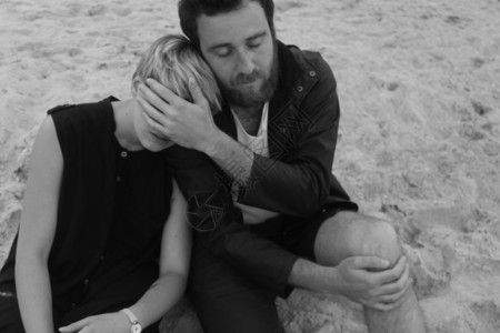 放松的坐在沙滩上的小情侣高清图片