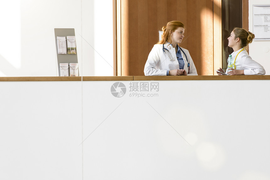 两名年轻女医生靠在阳台说话图片