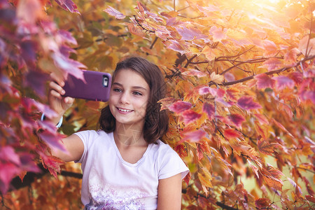 年轻女孩用智能手机自拍图片