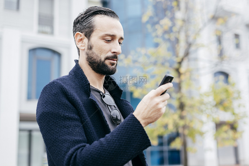 在街上看手机的成熟男性图片